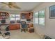 Bright office space with built-in desks, cabinets, and a leafy ceiling fan at 1104 Northridge Dr, Palm Harbor, FL 34683