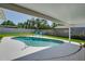 Backyard kidney shaped pool with white concrete deck and two blue Adirondack chairs. Fully fenced yard at 1104 Northridge Dr, Palm Harbor, FL 34683