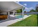 Cozy kidney shaped pool with covered lanai, hot tub, outdoor shower and green lawn at 1104 Northridge Dr, Palm Harbor, FL 34683
