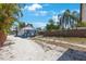 A spacious backyard with a wooden fence, stepping stones, and lush palm trees, perfect for outdoor activities and privacy at 1110 36Th N Ave, St Petersburg, FL 33704
