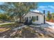 A quaint, well-maintained house with a lush tree, showcasing its inviting curb appeal and cozy design at 1110 36Th N Ave, St Petersburg, FL 33704