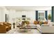 Inviting living room with a sectional sofa, coffee table, and seamless flow into the modern kitchen at 11817 Sparkling Topaz Cv, Parrish, FL 34219