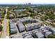 Aerial view showcases a community of townhomes, a lake, and a city skyline in the distance in this peaceful neighborhood at 1182 25Th N Way, St Petersburg, FL 33713