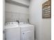 Functional laundry room with white washer and dryer, and storage shelf at 1182 25Th N Way, St Petersburg, FL 33713