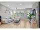Inviting living room with light hardwood floors, a white sofa set, and natural light streaming through the multiple windows at 1182 25Th N Way, St Petersburg, FL 33713