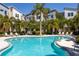 Inviting community pool area with palm trees, lounge chairs, and modern buildings. A tropical oasis for relaxation at 1182 25Th N Way, St Petersburg, FL 33713