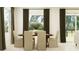 Cozy dining room featuring a wooden table with seating for six, neutral decor, and large windows at 11829 Sparkling Topaz Cv, Parrish, FL 34219