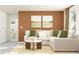 Well-lit living room with a plush sofa, modern artwork, and a glimpse into the adjacent bathroom at 11829 Sparkling Topaz Cv, Parrish, FL 34219