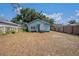 Fenced backyard view featuring the home's exterior, with a clean and well-maintained lawn at 1207 E Giddens Ave, Tampa, FL 33603