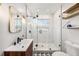 Stylish bathroom with glass enclosed shower, wood vanity and decorative herringbone tiled walls at 1207 E Giddens Ave, Tampa, FL 33603