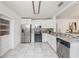 Well-lit kitchen with white cabinetry, granite counters, stainless appliances and tiled floor at 1207 E Giddens Ave, Tampa, FL 33603