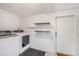 Functional laundry room with washer, dryer, shelving and access to the exterior at 1207 E Giddens Ave, Tampa, FL 33603