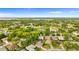 An aerial view of a home surrounded by lush greenery and a serene pond, nestled in a peaceful neighborhood at 1218 Gillespie N Dr, Palm Harbor, FL 34684