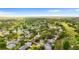 A high angle aerial view showcases the property and neighboring homes surrounded by a lush, green landscape at 1218 Gillespie N Dr, Palm Harbor, FL 34684