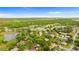 An aerial view of a home near a scenic pond and lush greenery offers a serene neighborhood setting at 1218 Gillespie N Dr, Palm Harbor, FL 34684