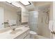 Bathroom featuring a stand up shower with glass door, a marble sink, and a skylight at 1218 Gillespie N Dr, Palm Harbor, FL 34684