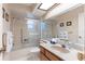 Bathroom featuring a shower and tub combination with glass door, a marble sink, and a skylight at 1218 Gillespie N Dr, Palm Harbor, FL 34684