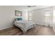 Cozy bedroom boasts wood laminate flooring, a ceiling fan, a large window, and classic furnishings at 1218 Gillespie N Dr, Palm Harbor, FL 34684