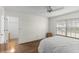 Bright bedroom with a closet and light wood laminate flooring boasts a ceiling fan and a large window at 1218 Gillespie N Dr, Palm Harbor, FL 34684