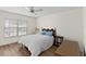 Bedroom boasts wood laminate flooring, a ceiling fan, a large window, and classic furnishings at 1218 Gillespie N Dr, Palm Harbor, FL 34684