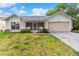 Charming single-story home with a front porch, two-car garage and well-maintained lawn in a quiet neighborhood at 1218 Gillespie N Dr, Palm Harbor, FL 34684