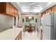 Bright kitchen features wooden cabinets, white appliances, and an adjacent dining area with backyard views at 1218 Gillespie N Dr, Palm Harbor, FL 34684