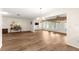 This expansive living room features wood floors, a fan, and many windows overlooking the front yard at 1218 Gillespie N Dr, Palm Harbor, FL 34684