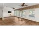 This open-concept living room includes wood floors, lots of natural light, and a ceiling fan at 1218 Gillespie N Dr, Palm Harbor, FL 34684
