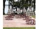 Outdoor picnic area featuring multiple tables and umbrellas for guests to enjoy outdoor dining with a BBQ grill at 1218 Gillespie N Dr, Palm Harbor, FL 34684