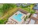 An aerial shot highlights the pool and the spa and their attractive lounge areas and lush, tropical landscaping at 1218 Gillespie N Dr, Palm Harbor, FL 34684