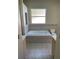 Bright bathroom with a tiled jacuzzi tub under a window, and a toilet in a neutral color scheme at 13211 Park Blvd, Seminole, FL 33776