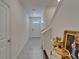 Clean, tiled hallway with white trim and staircase, leading to the front door at 138 Mangrove Shade Cir, Apollo Beach, FL 33572