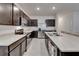 Spacious kitchen featuring stainless steel appliances, dark cabinets, and a large center island at 138 Mangrove Shade Cir, Apollo Beach, FL 33572
