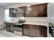 Contemporary kitchen featuring stainless steel appliances, dark cabinets, and quartz countertops at 138 Mangrove Shade Cir, Apollo Beach, FL 33572