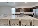Open kitchen with island seating, stainless steel appliances, and dark cabinets at 138 Mangrove Shade Cir, Apollo Beach, FL 33572