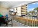 Private balcony overlooking the parking and nearby building with tropical landscaping at 1412 Gulf Blvd # 103A, Indian Rocks Beach, FL 33785