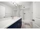 Modern bathroom with an updated navy vanity and shower and tub combination at 1412 Gulf Blvd # 103A, Indian Rocks Beach, FL 33785