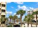 Beach view from a balcony of a condo with palms and a blue sky at 1412 Gulf Blvd # 103A, Indian Rocks Beach, FL 33785