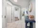 Bright tiled hallway with decorative table, modern lighting and doors to the living space at 1412 Gulf Blvd # 103A, Indian Rocks Beach, FL 33785