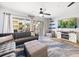 Bright living room with a plush sofa, entertainment center, and sliding doors to the balcony at 1412 Gulf Blvd # 103A, Indian Rocks Beach, FL 33785