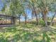 Large backyard with mature trees, lush lawn, and a screened patio at 1530 High Knoll Dr, Brandon, FL 33511