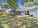 Spacious backyard with screened-in patio, mature trees, and room to entertain at 1530 High Knoll Dr, Brandon, FL 33511