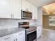 Bright kitchen with stainless appliances and white cabinets, next to view of a large dining room at 1530 High Knoll Dr, Brandon, FL 33511