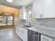 This bright, renovated kitchen features white cabinets, stainless appliances, granite counters, and gray tile backsplash at 1530 High Knoll Dr, Brandon, FL 33511
