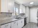 Bright kitchen features stainless steel appliances, granite counters, tile backsplash, and wood look tile flooring at 1530 High Knoll Dr, Brandon, FL 33511