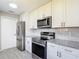 Updated kitchen with stainless steel appliances, granite countertops, and white cabinetry at 1530 High Knoll Dr, Brandon, FL 33511
