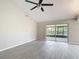 Spacious living room with ceiling fan, sliding glass doors to screened lanai, and neutral tile flooring at 1530 High Knoll Dr, Brandon, FL 33511
