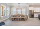 Bright dining area with modern table, chairs, bench, and stainless steel fridge at 16677 Vibrato Ln, Land O Lakes, FL 34638