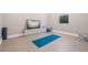 Clean and functional exercise room with yoga mat, TV, storage cabinet, and natural light at 16677 Vibrato Ln, Land O Lakes, FL 34638