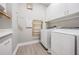 Well-lit laundry room featuring a modern washer and dryer, storage cabinets, and a convenient folding rack at 16677 Vibrato Ln, Land O Lakes, FL 34638